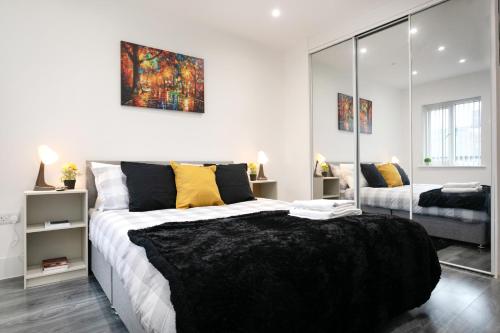 a bedroom with a large bed and a mirror at Nottingham Top Serviced Home - Chayil Experts in Nottingham