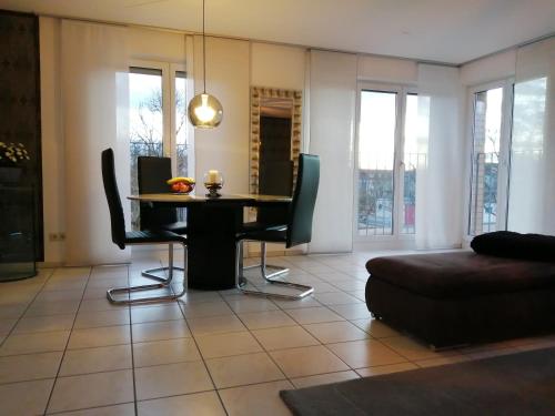 ein Wohnzimmer mit einem Tisch und Stühlen in der Unterkunft Schicke 2 Zimmer Wohnung nah an Stuttgart Messe Flughafen in Ostfildern