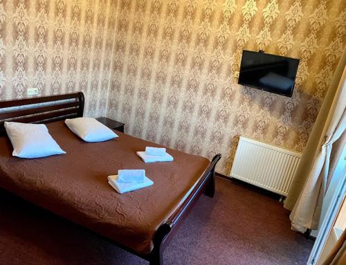 a bedroom with a bed with two towels on it at Golden Lion Hotel in Boryspilʼ