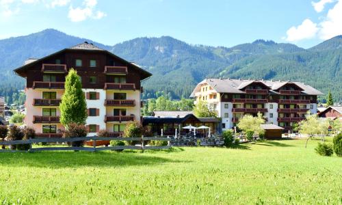 a hotel in a field with mountains in the background at Gosau Apartment 209 in Gosau