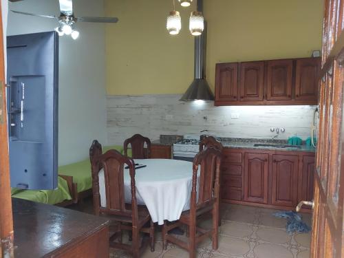 a kitchen with a table with chairs and a refrigerator at Chapadmalal Casas La Bella in Colonia Chapadmalal