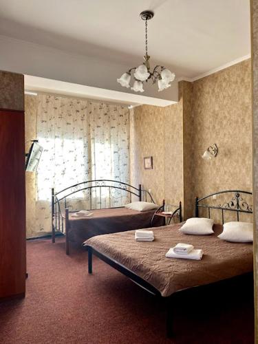a bedroom with two beds and a window at Golden Lion Hotel in Boryspilʼ