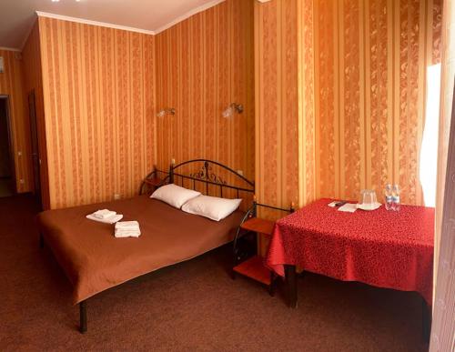 a bedroom with a bed and a table with towels on it at Golden Lion Hotel in Boryspilʼ