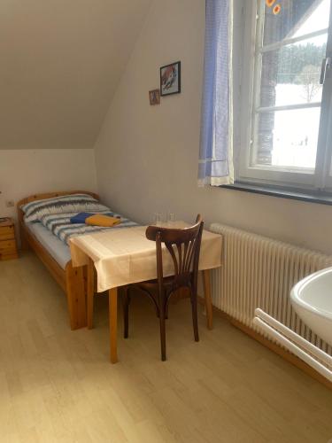 a bedroom with a table and a bed and a sink at Viehberghütte in Sandl