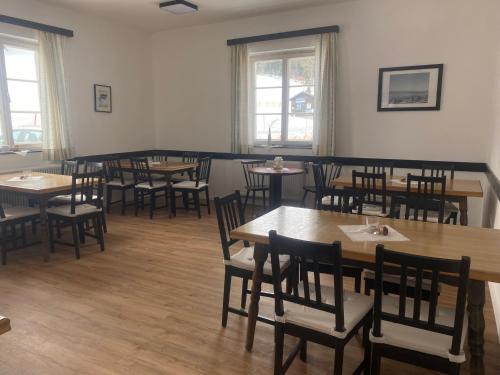 a dining room with tables and chairs and windows at Viehberghütte in Sandl