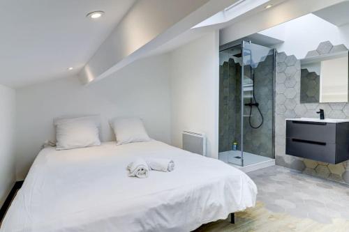 a bedroom with a large white bed and a sink at LA CAMBUSE TOPDESTINATION-BOURG - Centre ville - Classé 3 étoiles in Bourg-en-Bresse