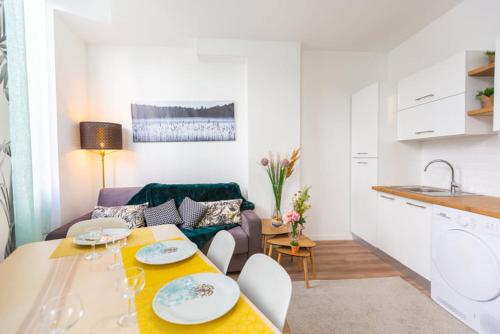 a kitchen and living room with a table and a couch at Bel appartement Type T3 climatisé in Marseille