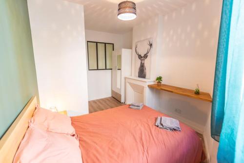 a bedroom with a bed with orange sheets and a deer head on the wall at Bel appartement Type T3 climatisé in Marseille