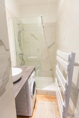 a bathroom with a shower and a washing machine at Bel appartement Type T3 climatisé in Marseille