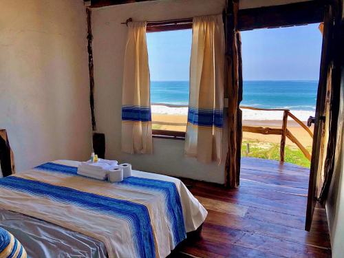- une chambre avec un lit et une vue sur l'océan dans l'établissement Casa Obe, à Yolina