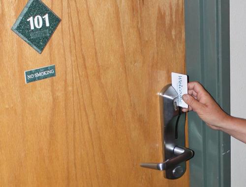 a person opening a door with a no smoking sign at Hilltop Inn by Riversage in Billings