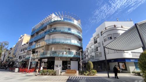 un edificio de apartamentos alto con un hombre parado frente a él en TORREMOLINOS - NEW CENTRAL STUDIO PLATA WITH BALCONY, en Torremolinos