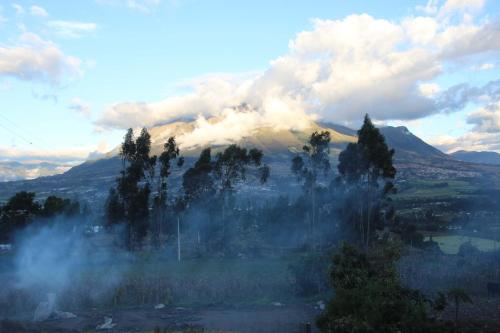 a view of a mountain with clouds and trees at Casa Hotel Loma Wasi en Cotacachi in Cotacachi