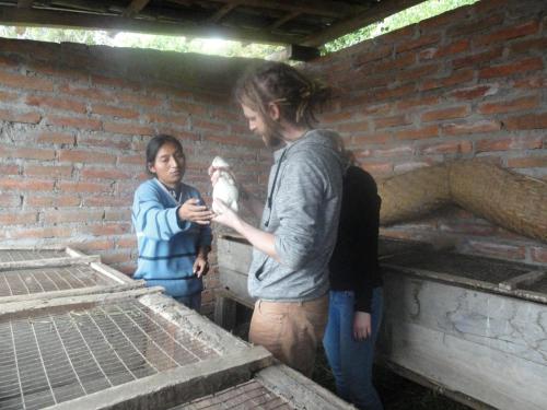 a group of people standing next to a brick wall at Casa Hotel Loma Wasi en Cotacachi in Cotacachi