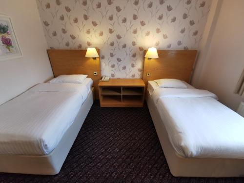 A bed or beds in a room at Chichester Park Hotel