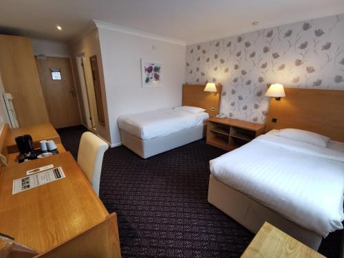 A bed or beds in a room at Chichester Park Hotel