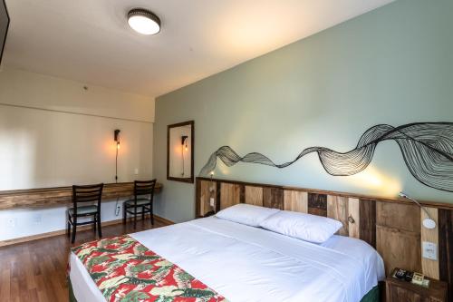 a bedroom with a bed and a table and chairs at Eko Residence Hotel - próximo a Santa Casa e Auditório Araujo Vianna in Porto Alegre