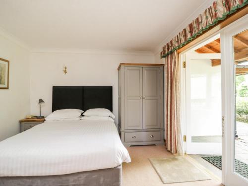 a bedroom with a white bed and a sliding glass door at Thirlmere Suite in Thirlmere