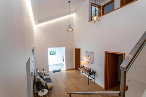 a living room with white walls and a staircase at Carvão PDL Inn in Ponta Delgada