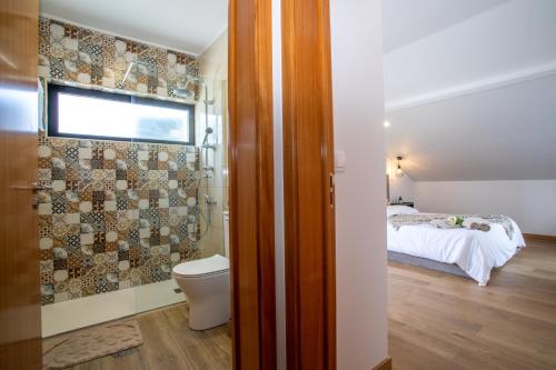 Un baño con inodoro y una cama en una habitación. en Carvão PDL Inn, en Ponta Delgada