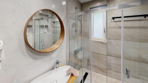 Yalos luxury home في Agii Saranta: حمام مع دش ومغسلة ومرآة