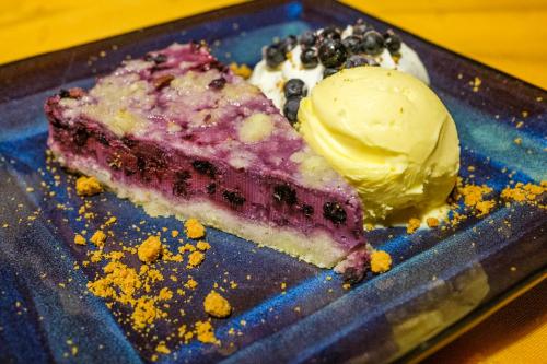 a piece of cake and ice cream on a blue plate at Hotel Kačenka in Králíky