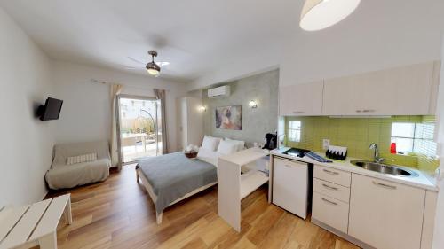 a kitchen and living room with a bed and a sink at Studios Yalos in Chorefto