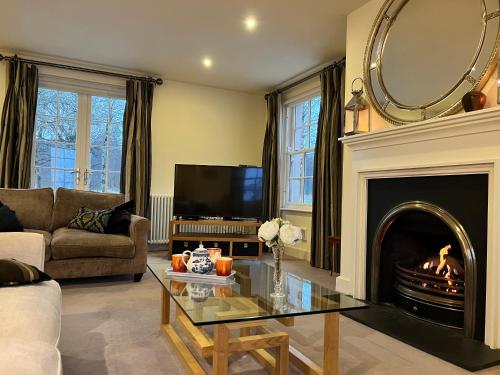 a living room with a fireplace and a mirror at The Lough Erne House at Golf Village Lough Erne Resort in Enniskillen