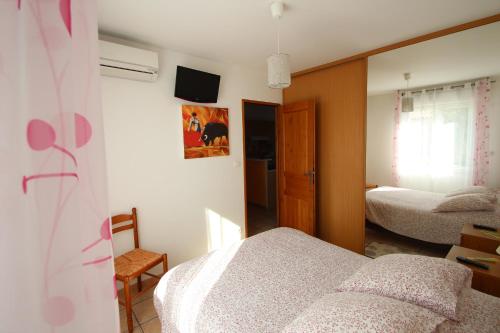 サン・マルタン・ド・クロにあるオテル エ レジデンス ド ラ トランシュマンスのベッドルーム1室(ベッド2台、鏡付)