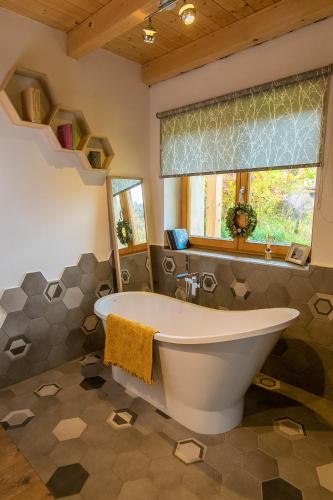 a bathroom with a large tub and a window at Boglya Ökoház in Ozora