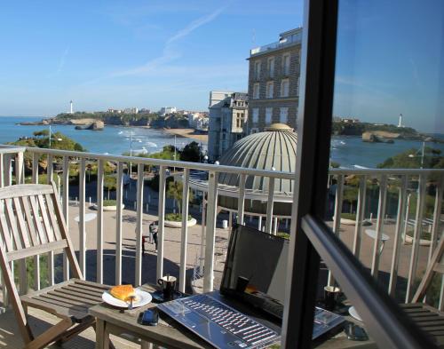 a laptop computer sitting on a table on a balcony at Hotel De L'Océan in Biarritz