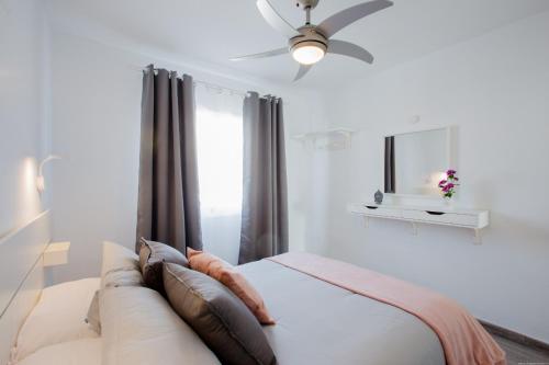 a bedroom with a couch and a ceiling fan at El Beril 82, Tenerife in Adeje