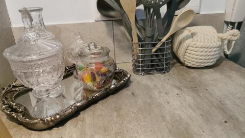 a counter with a glass jar and a tray with utensils at Pebble Gardens Swakopmund in Swakopmund