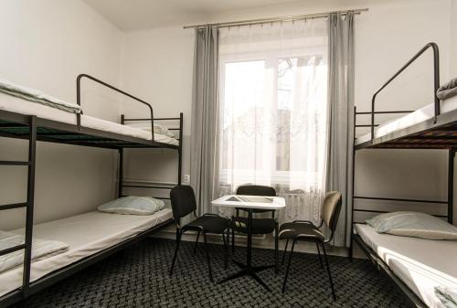 a room with bunk beds and a table and chairs at Noclegi PODZAMCZE PTTK in Przemyśl