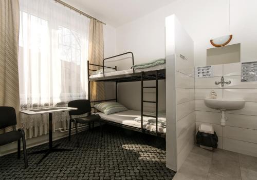 a room with two bunk beds and a sink at Noclegi PODZAMCZE PTTK in Przemyśl