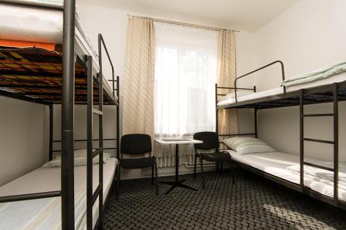 a dorm room with two bunk beds and a desk at Noclegi PODZAMCZE PTTK in Przemyśl