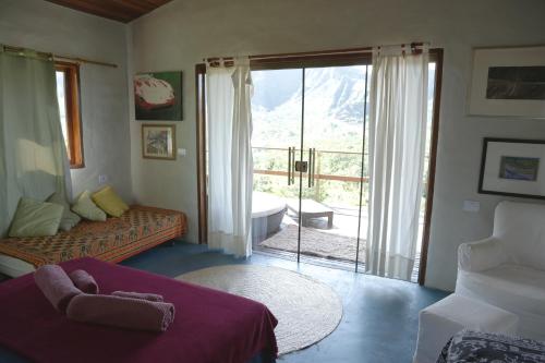 a bedroom with a bed and a sliding glass door at Chale duplex com vista para a Serra do Segredo in Sao Jorge