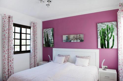 a bedroom with purple walls and a white bed at Apartment, Los Llanos de Aridane in Los Llanos de Aridane