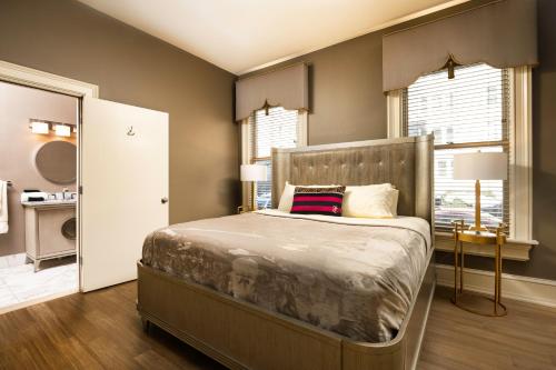 a bedroom with a large bed in a room with windows at The Edward Buffalo in Buffalo