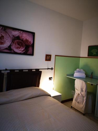 a bedroom with a bed and a shelf with roses on the wall at Residence SANTA CROCE Delebio Provincia di Sondrio in Sondrio