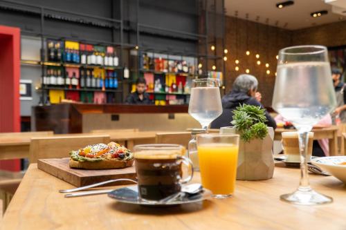 a table with glasses of orange juice and a plate of food at Selina Salta in Salta