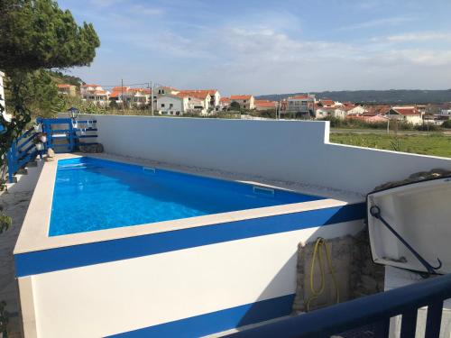 a white and blue swimming pool on a white wall at Villa Praia in São Martinho do Porto