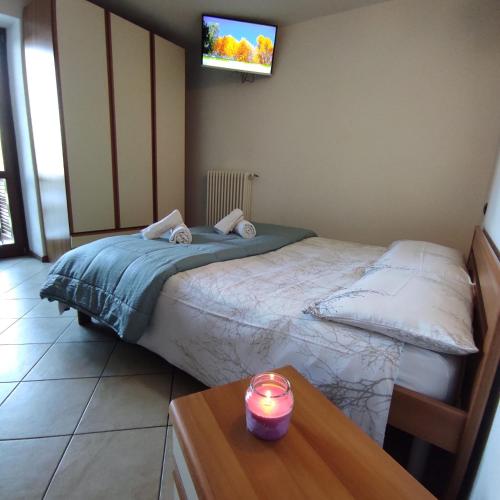 a bedroom with a bed and a candle on a table at Orobie Holiday Apartments in Albosaggia