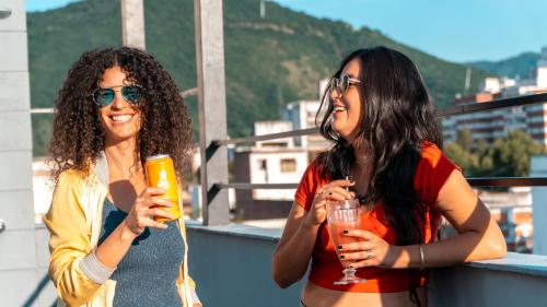 two women standing on a balcony holding drinks at Selina Salta in Salta