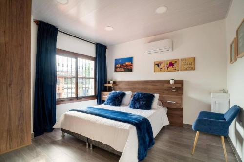 Un dormitorio con una cama y una silla azul. en Modern, Luxurious and Tradicional Apartments by Samilis Place, en Cali