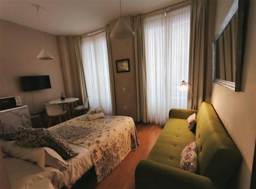una habitación de hotel con una cama y un sofá en Art and Night - City Center Studio, en Málaga