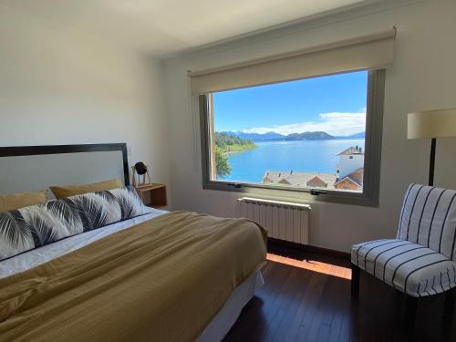 a bedroom with a large window with a view of a lake at Quinta Luna in San Carlos de Bariloche