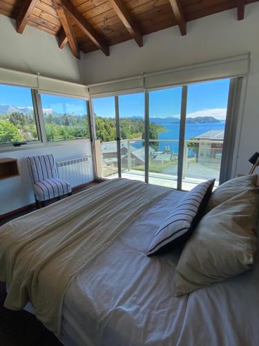 a bedroom with a large bed with a large window at Quinta Luna in San Carlos de Bariloche