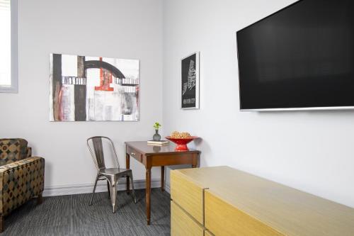 a living room with a desk and a tv at Retro Suites Hotel in Chatham