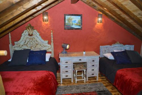 a bedroom with two beds and a desk in a attic at Casa do Ti Gabriel in Sabugueiro